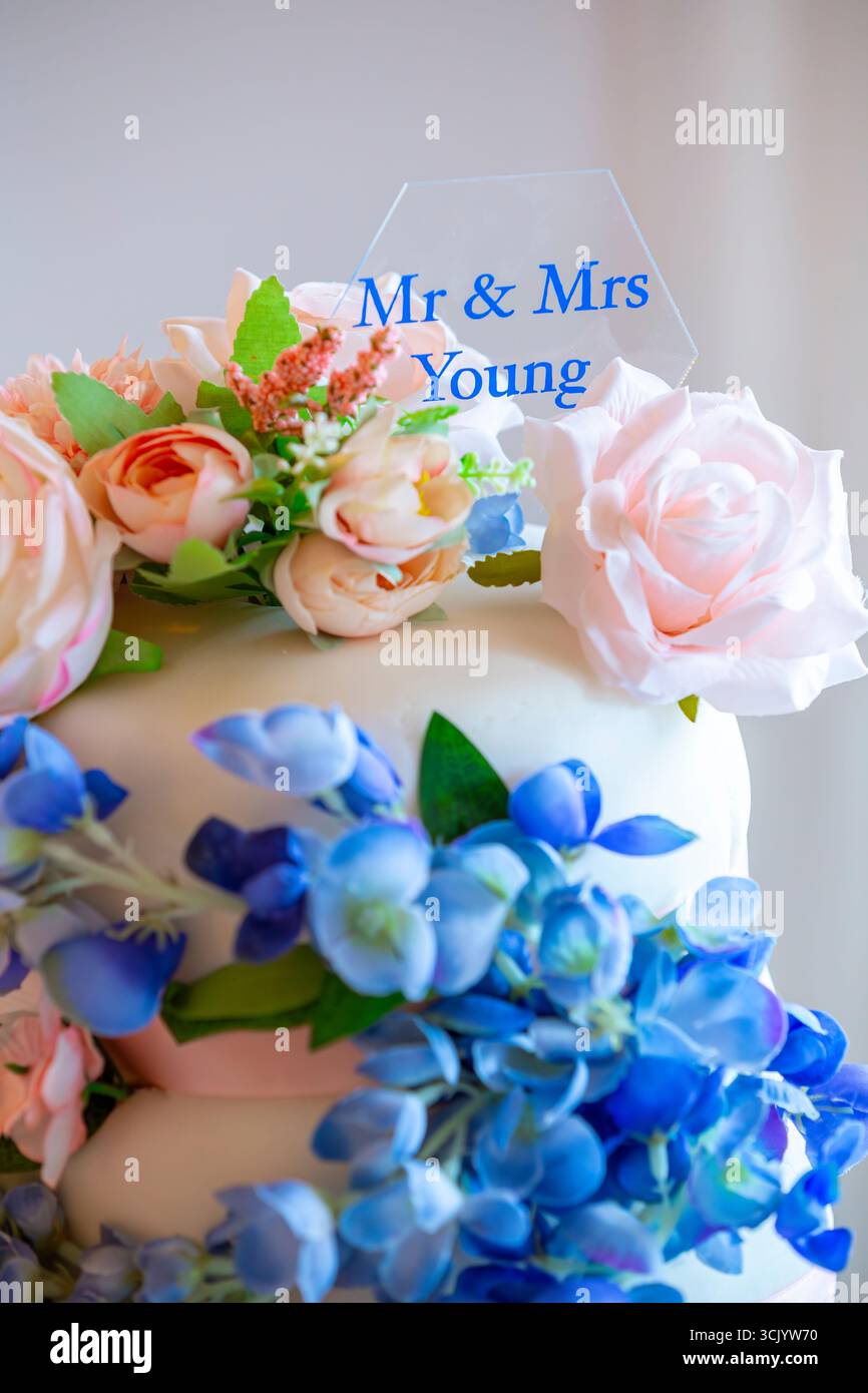 Élégant gâteau de mariage orné d'un affichage en cascade de pivoines artificielles et d'hortensias Banque D'Images
