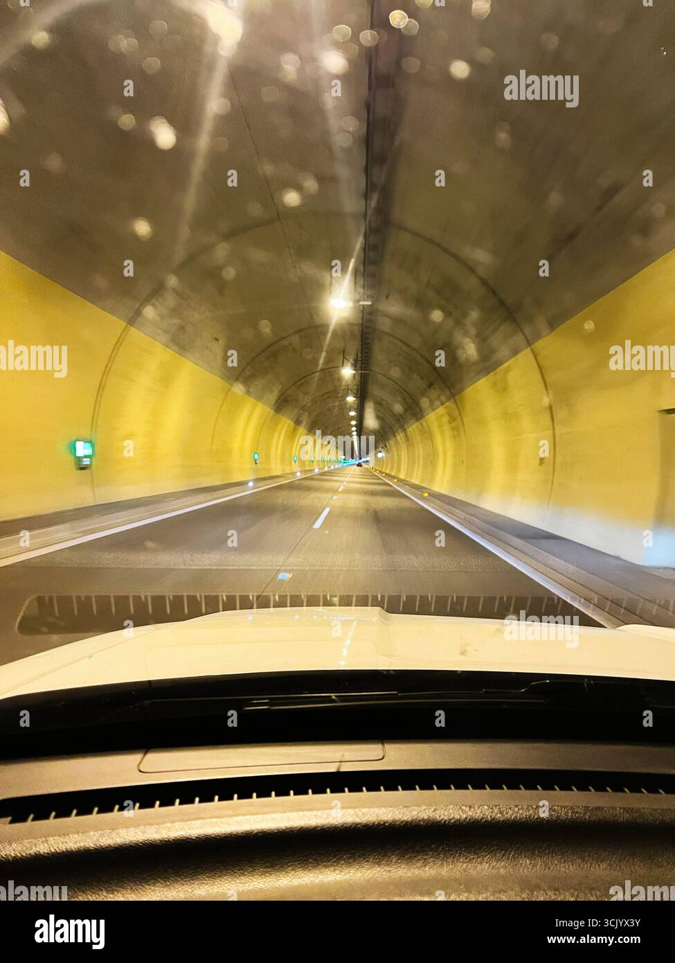 Vue d'une voiture circulant à l'intérieur d'une chaussée de tunnel en béton bien éclairée Banque D'Images