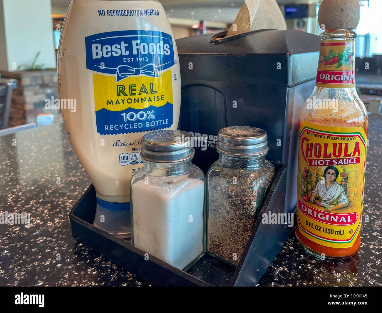 Contenant de serviette avec des condiments sur la table de restaurant informelle, États-Unis 2025 Banque D'Images