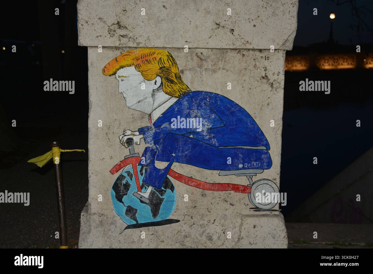 Graffiti politique à Rome, Italie (2019) représentant une caricature de Donald Trump chevauchant un tricycle avec la Terre comme roue avant, rue satirique Banque D'Images