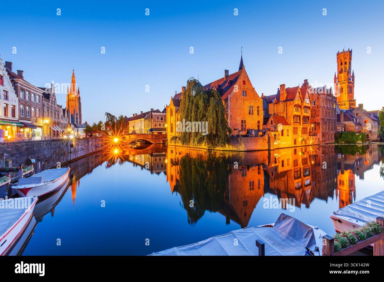 Bruges, Belgique. La Rozenhoedkaai canal de Bruges avec le beffroi en arrière-plan. Banque D'Images