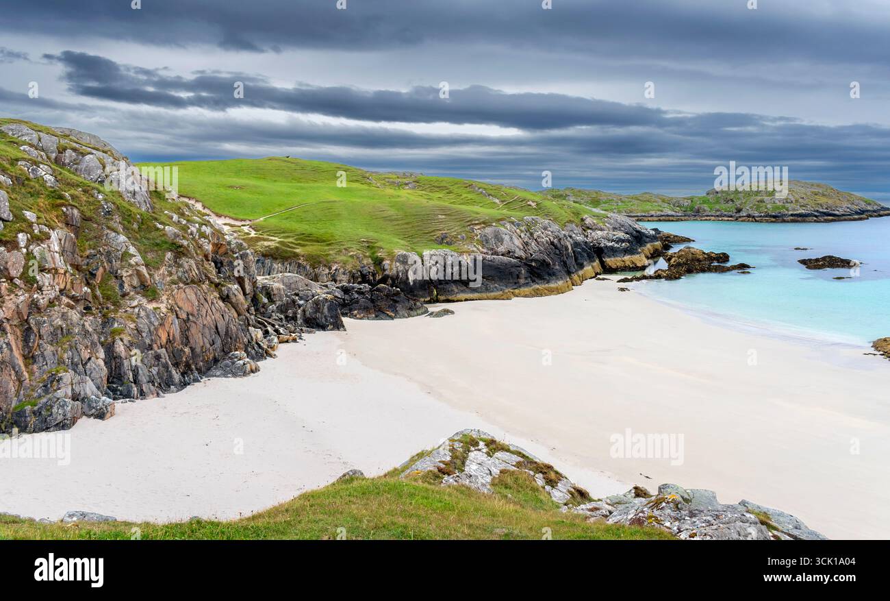 Achmelvich Lochinver Sutherland Écosse un ciel sombre bleu turquoise et le sable blanc de la plage de Vestey Banque D'Images