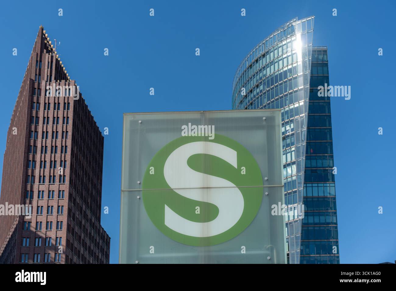 Un symbole S-Bahn devant les gratte-ciel de Potsdamer Platz. Le cercle vert brille contre un ciel bleu. Banque D'Images