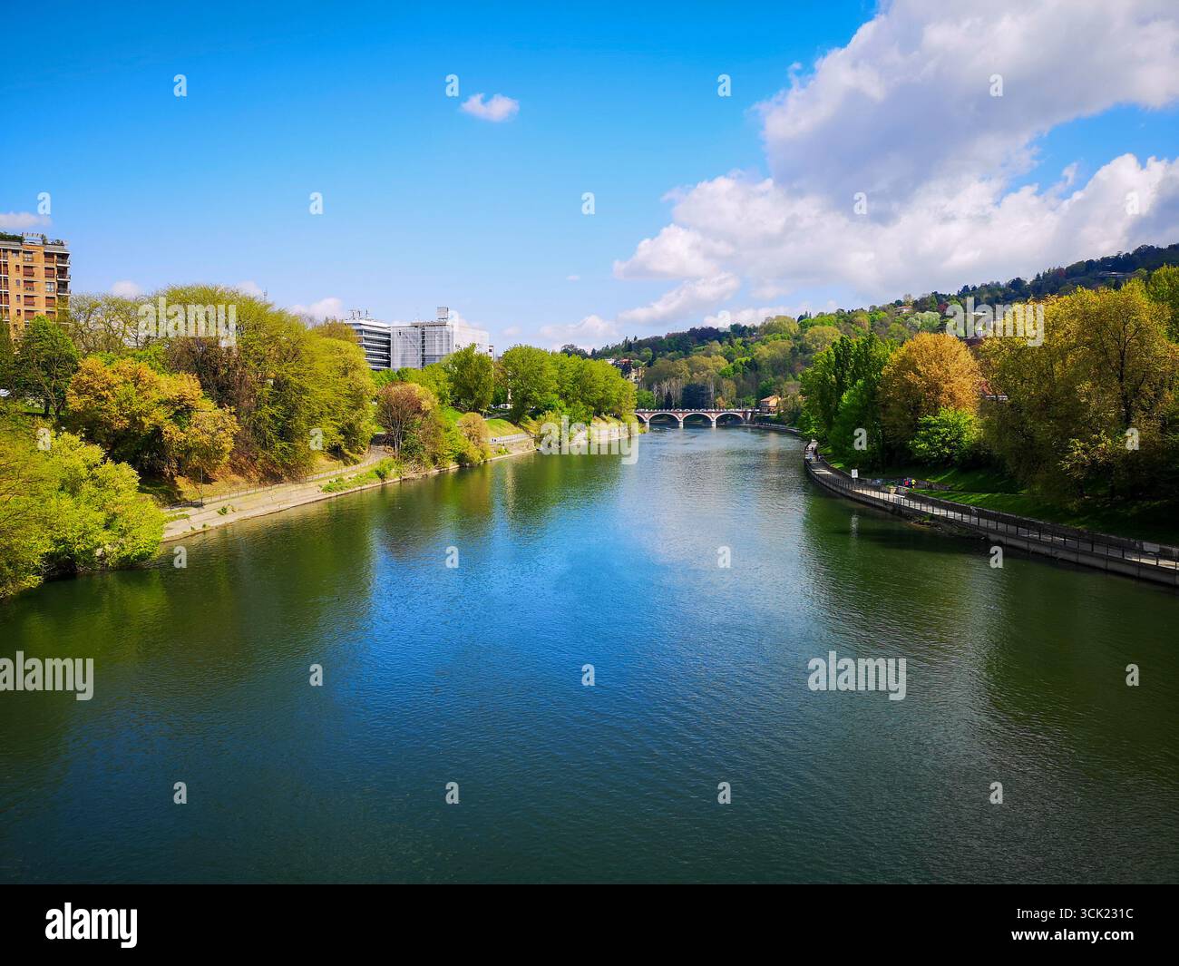 Une vue panoramique sur le fleuve Pô qui traverse Turin, Italie, par une journée ensoleillée et lumineuse. L'eau calme et bleue de la rivière est bordée par un feuillage vert luxuriant - Image de stock capturée avec un smartphone