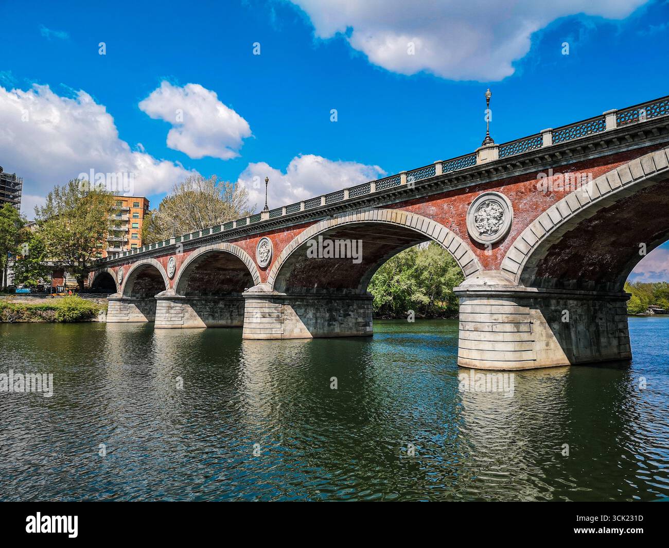 Une vue panoramique du Ponte Isabella, un pont historique avec des arches en briques rouges et des accents de pierre blanche, traversant le fleuve Pô à Turin, en Italie. Le calme, gre - Image de stock capturée avec un smartphone