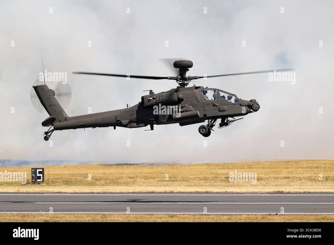 Boeing Apache AH2 L'hélicoptère Apache ZM745 de l'armée britannique plane devant un mur de fumée blanche alors qu'il démontre ses capacités pendant le RIAT Banque D'Images Boeing Apache AH2 L'hélicoptère Apache ZM745 de l'armée britannique plane devant un mur de fumée blanche alors qu'il démontre ses capacités pendant le RIAT Banque D'Images