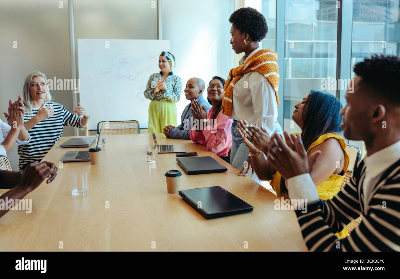 Une réunion réussie du conseil d'administration met en vedette un groupe diversifié de professionnels applaudissant une présentation. Mettre en avant le travail d'équipe, le leadership, l'énergie positive et Banque D'Images