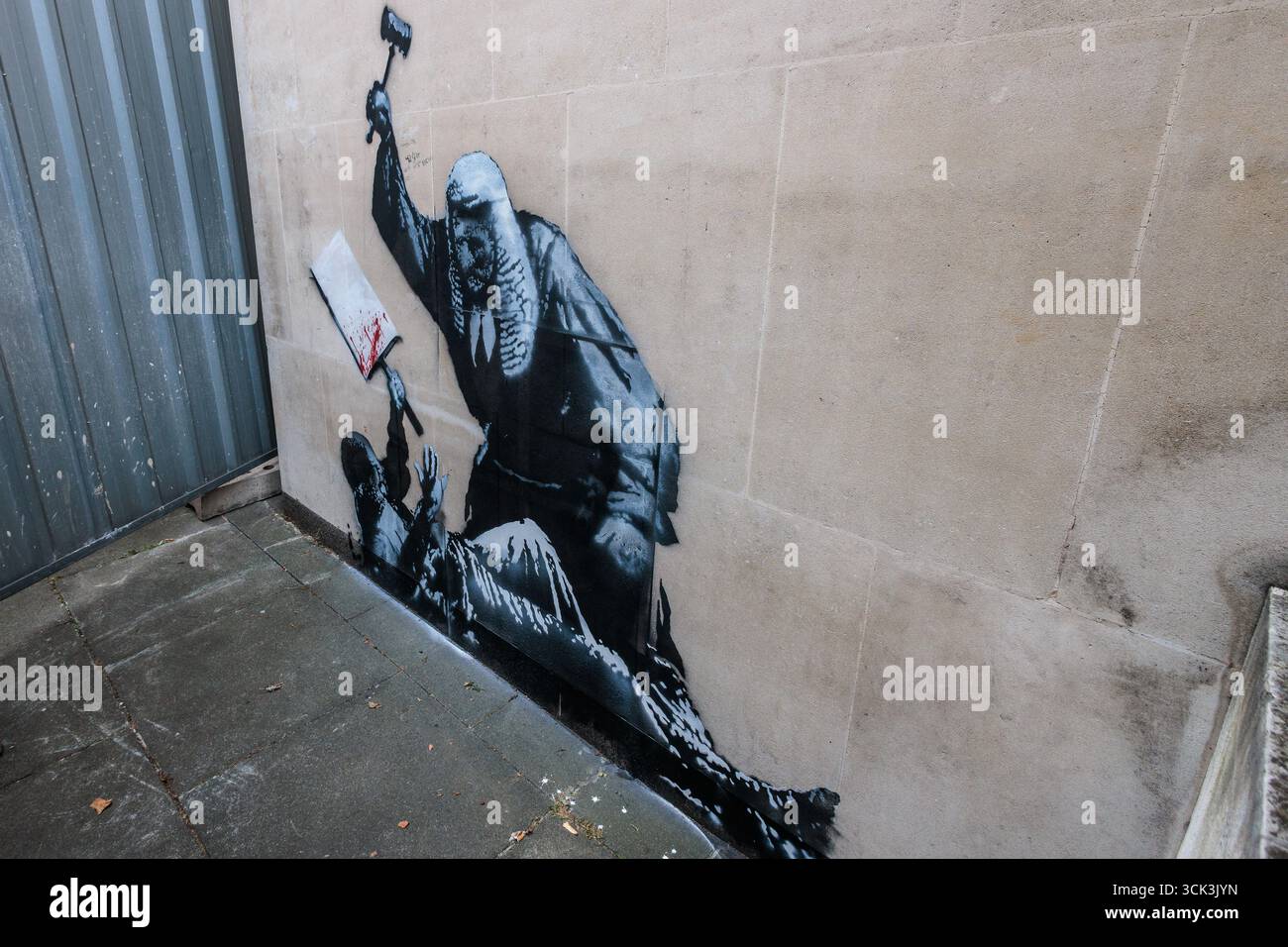 Londres, Royaume-Uni. 9 septembre 2025. Une nouvelle œuvre d'art Banksy sur un mur extérieur du Queen's Building des cours royales de justice est photographiée entre les barrières métalliques utilisées pour la dissimuler par les cours et tribunaux de SM. HM courts and Tribunals a indiqué que l'œuvre d'art, qui montre un juge dans une perruque et une robe utilisant un marteau pour frapper un manifestant avec une pancarte de sang éclaboussée, sera retirée. Crédit : Mark Kerrison/Alamy Live News Banque D'Images