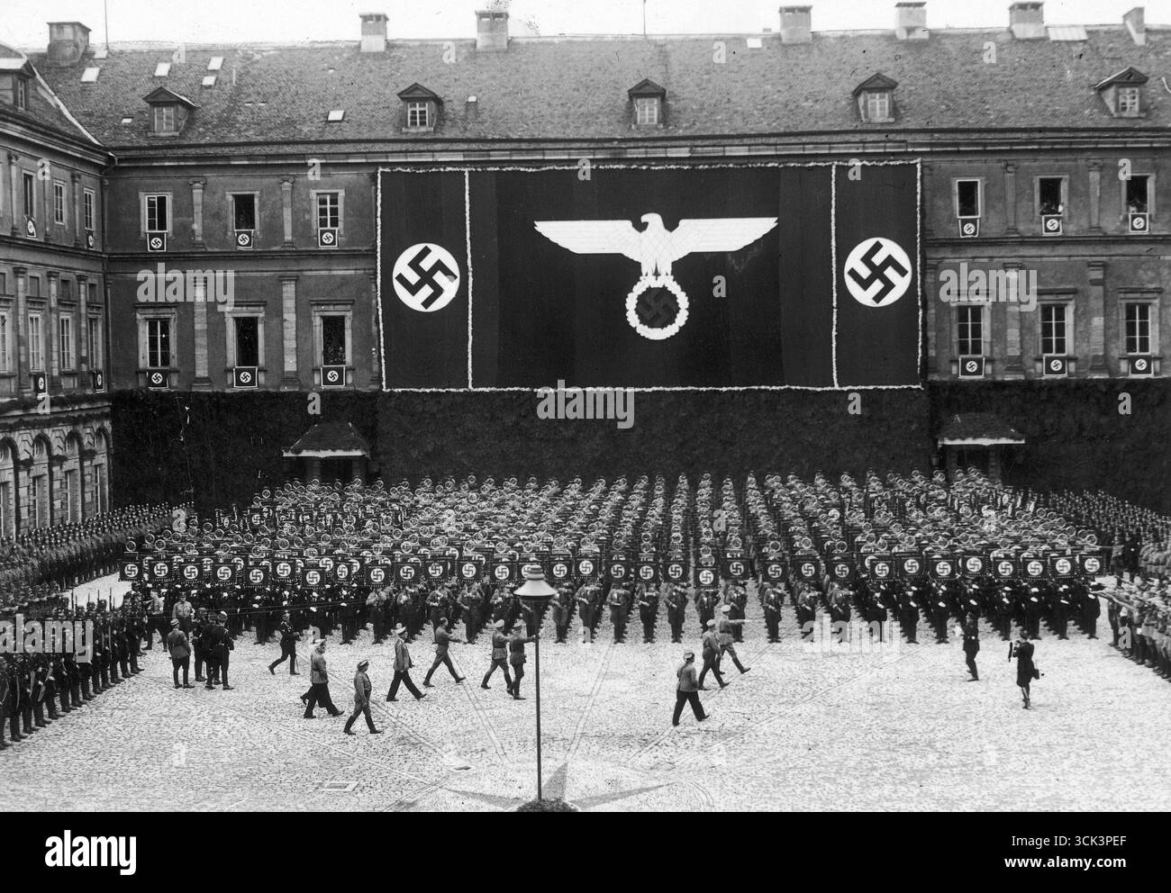 Le chef nazi et chancelier du Reich Adolf Hitler passe devant les porte-étendards. Drapeaux nazis et symboles visibles dans backgroiund. 1936 Banque D'Images