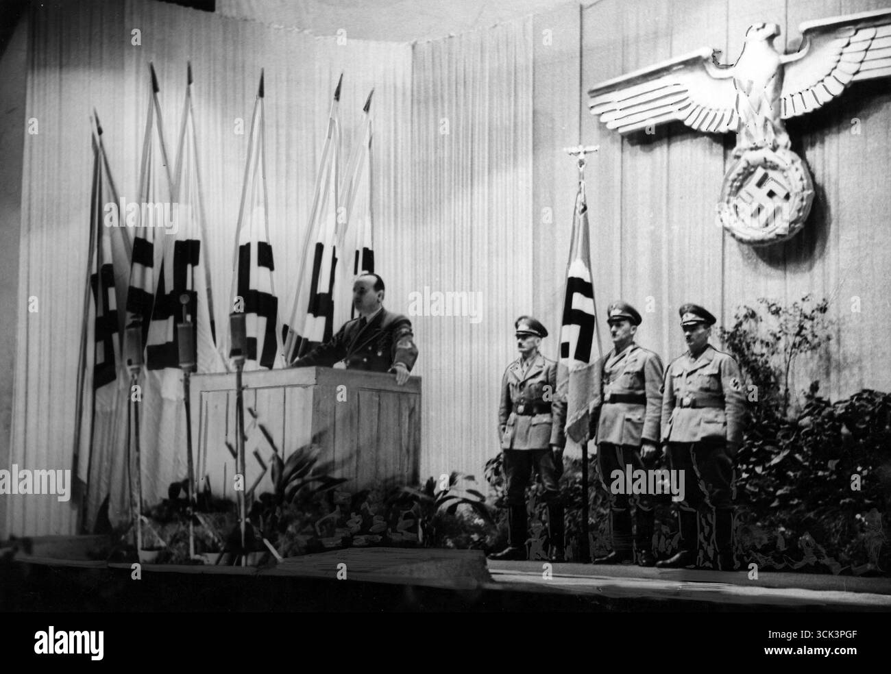 Réunion du parti nazi – rassemblement dans un théâtre de Lviv pour marquer l'anniversaire de l'arrivée au pouvoir d'Adolf Hitler. Le gouverneur Hans Frank prononce un discours. Les symboles du troisième Reich sont visibles, 1944 Banque D'Images
