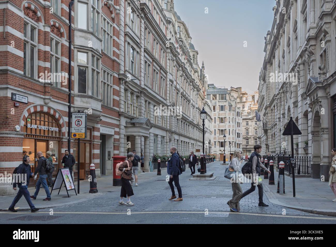 Les navetteurs tôt le matin traversant la rue, Londres, Grande-Bretagne. Banque D'Images