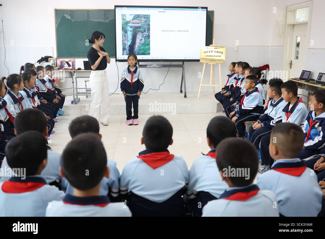 (250910) -- ZHANGXIAN, 10 septembre 2025 (Xinhua) -- des enfants interagissent avec un bénévole de la multinationale chinoise Lenovo lors d'une conférence sur le thème de l'IA à l'école Yanchuan du comté de Zhangxian, ville de Dingxi, province du Gansu, au nord-ouest de la Chine, le 10 septembre 2025. Avec des ordinateurs donnés par Lenovo et des bénévoles de la société, une salle de classe informatique a été construite à l'école Yanchuan du comté de Zhangxian. Lors d’un événement de bien-être public organisé à l’école mercredi, les étudiants et les professeurs ont pu se plonger dans le domaine de la technologie de l’IA via une conférence conçue par des experts de Lenov Banque D'Images