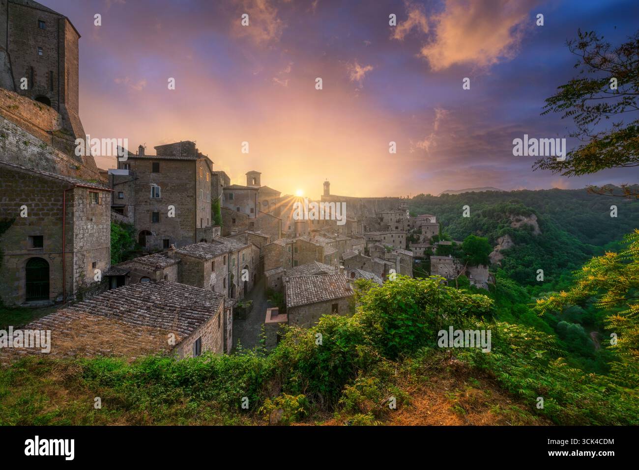 Coucher de soleil spectaculaire sur l'ancien village médiéval de Sorano en Maremme, Toscane. Bâtiments historiques en pierre et forteresse illuminés par la lumière dorée à d. Banque D'Images Coucher de soleil spectaculaire sur l'ancien village médiéval de Sorano en Maremme, Toscane. Bâtiments historiques en pierre et forteresse illuminés par la lumière dorée à d. Banque D'Images