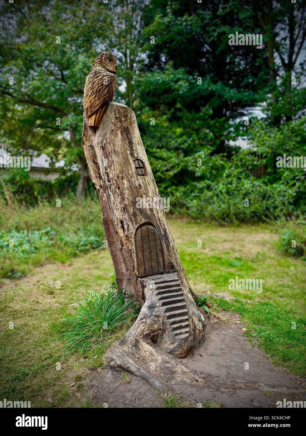 Sculpture d'arbre d'un hibou sur le dessus d'une maison façonnée à partir d'un tronc d'arbre dans court Hey Pak Liverpool. Banque D'Images