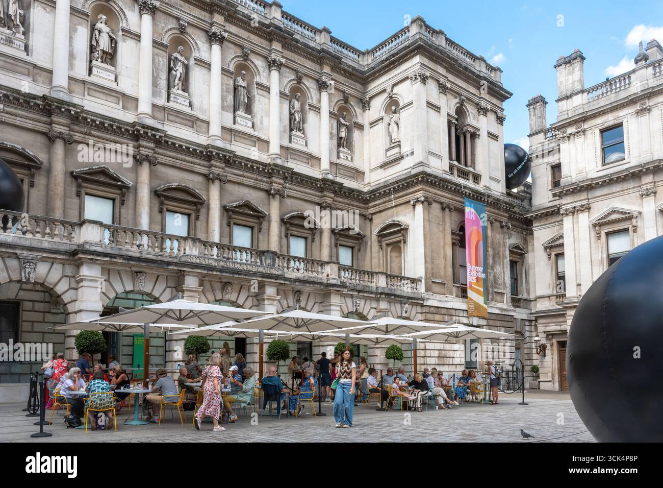 La Royal Academy of Arts à Londres, Angleterre, Royaume-Uni, vue extérieure lors de l'exposition annuelle d'été 2025 avec l'illustration de balles gonflables par Ryan Gander Banque D'Images