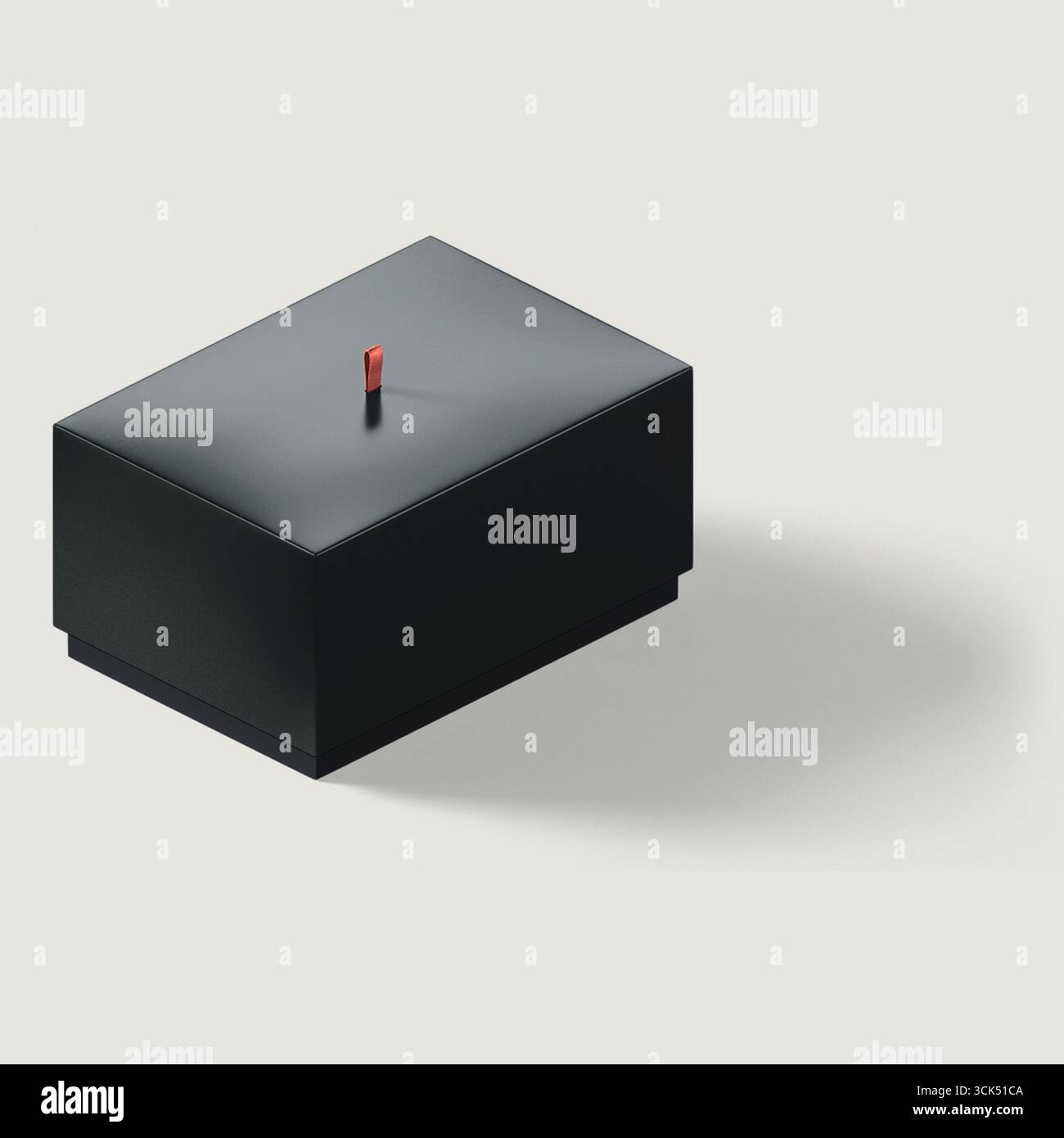 Une boîte noire minimaliste avec une petite poignée rouge, suggérant un but de stockage ou d'organisation. Banque D'Images