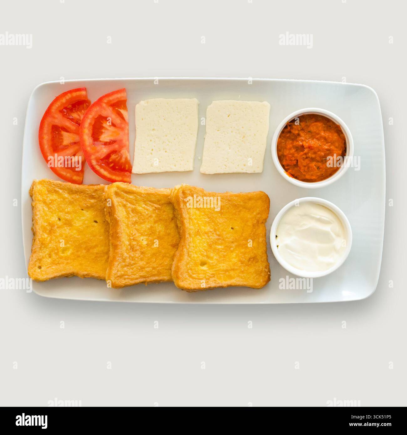 Une assiette pour le petit-déjeuner avec pain grillé, tomates, fromage et trempettes. Banque D'Images