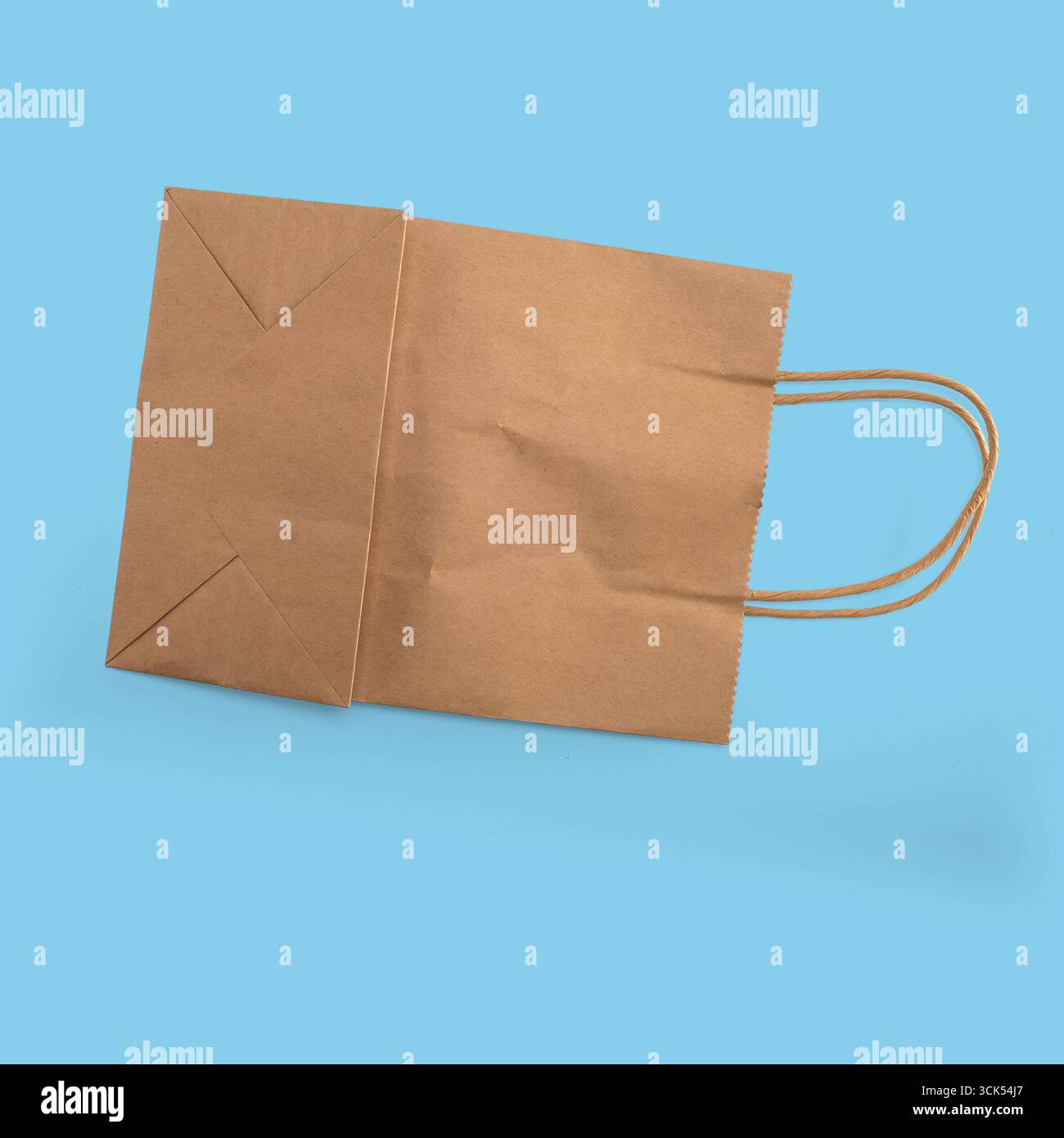Un sac en papier brun simple avec poignées, souvent utilisé pour faire du shopping ou transporter des articles. Banque D'Images