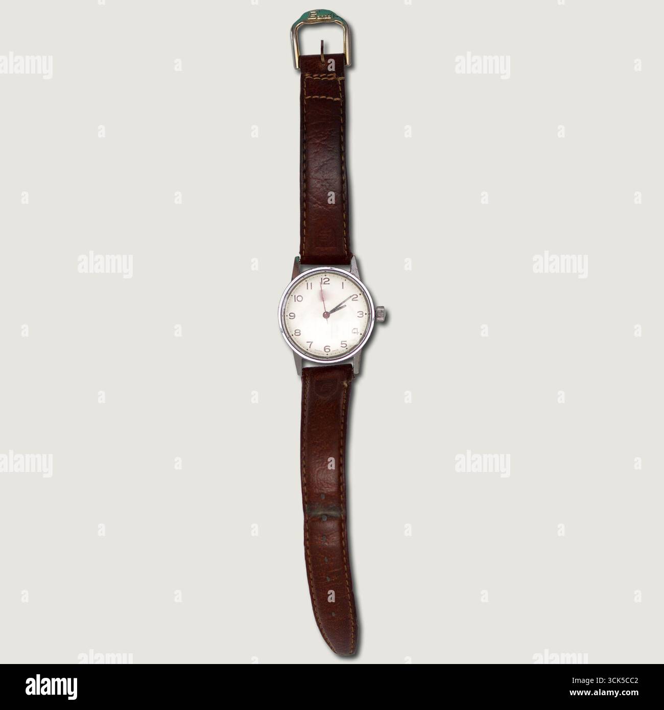 Une montre-bracelet classique avec un bracelet en cuir marron et un simple cadran blanc, conçue pour un usage quotidien. Banque D'Images
