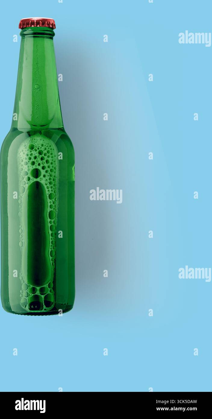 Une bouteille en verre vert remplie d'une boisson gazeuse, présentant des bulles et un design classique. Banque D'Images