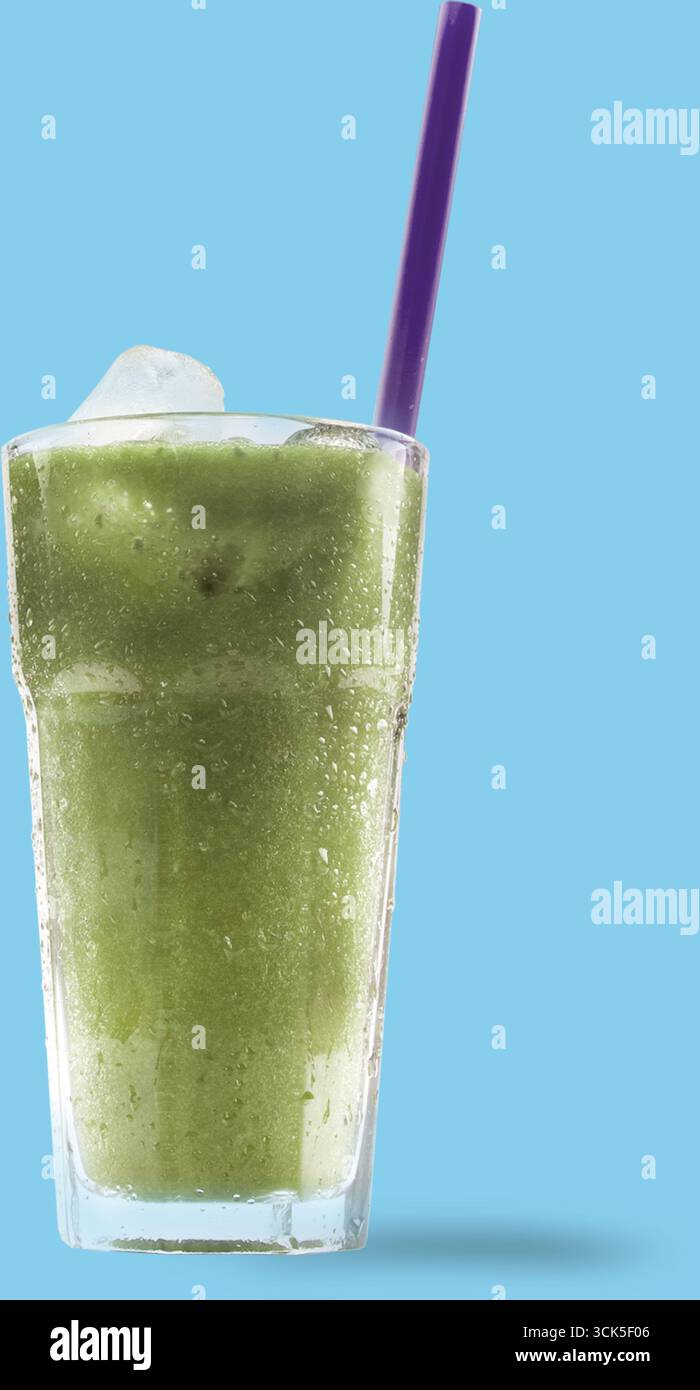 Une boisson verte rafraîchissante servie dans un grand verre avec de la glace et une paille violette. Banque D'Images
