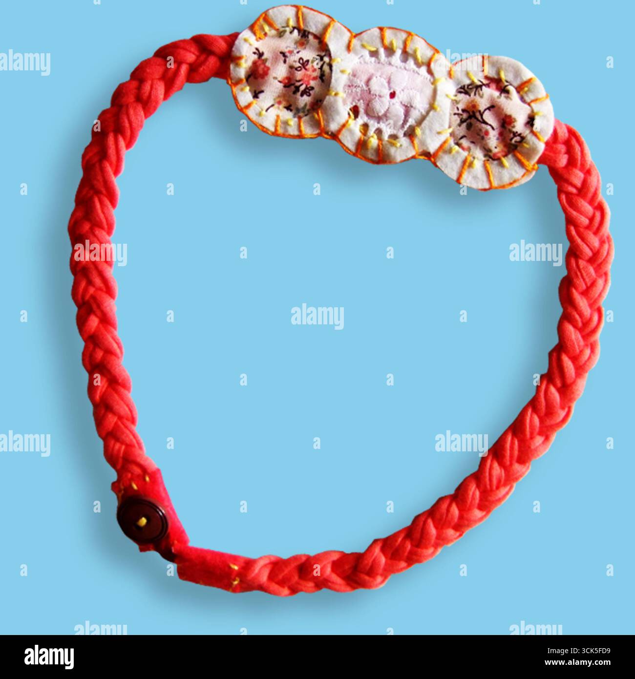 Arceau tressé aux couleurs vives avec éléments floraux décoratifs, adapté à la mode ou à l'amélioration de votre style personnel. Banque D'Images