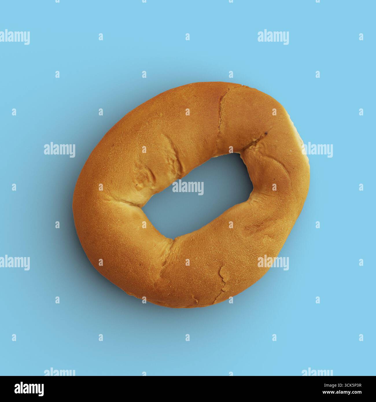 Un bagel rond, brun doré avec un trou au centre, souvent apprécié comme un élément de petit déjeuner ou une collation. Banque D'Images