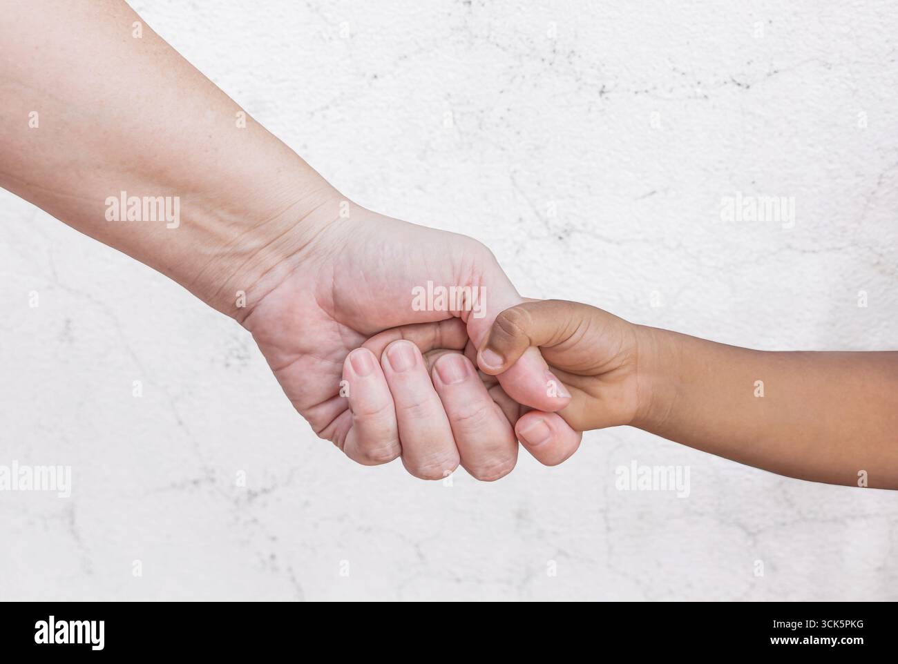Mains d'enfant et d'adulte. Famille interraciale tenant la main, mère caucasienne et fils ou filles à peau foncée. Concept de maternité et d'enfance. Gros plan Banque D'Images