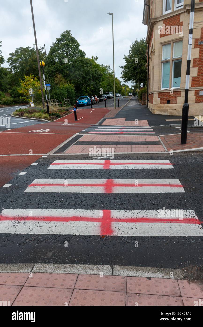 Farnborough, Hampshire, Angleterre, Royaume-Uni. Septembre 2025. Les croix de St George ont été peintes à la bombe sur un croisement zèbre avec de la peinture rouge. Des drapeaux similaires de l'Angleterre ou de l'Union Jack sont apparus à travers le pays récemment dans le cadre d'un mouvement de protestation anti-immigration par l'extrême droite. Banque D'Images