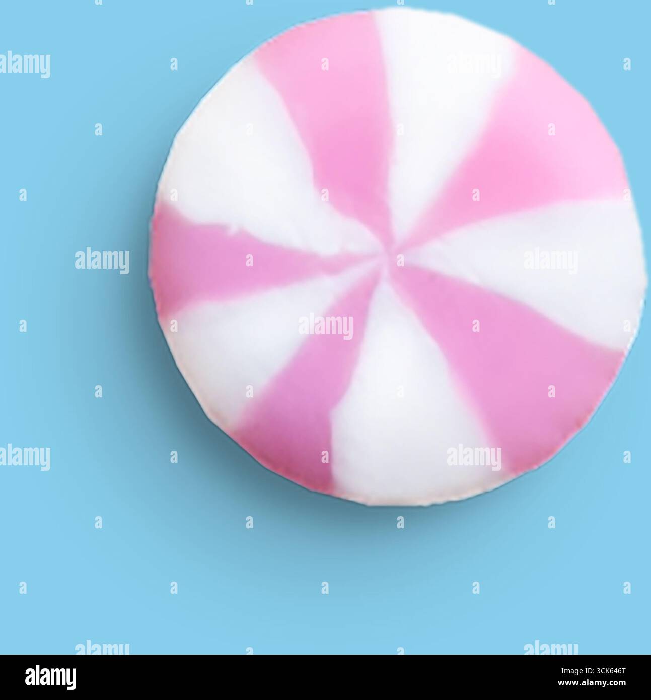Un bonbon rond et rayé avec des couleurs roses et blanches, ressemblant à une menthe poivrée classique. Banque D'Images