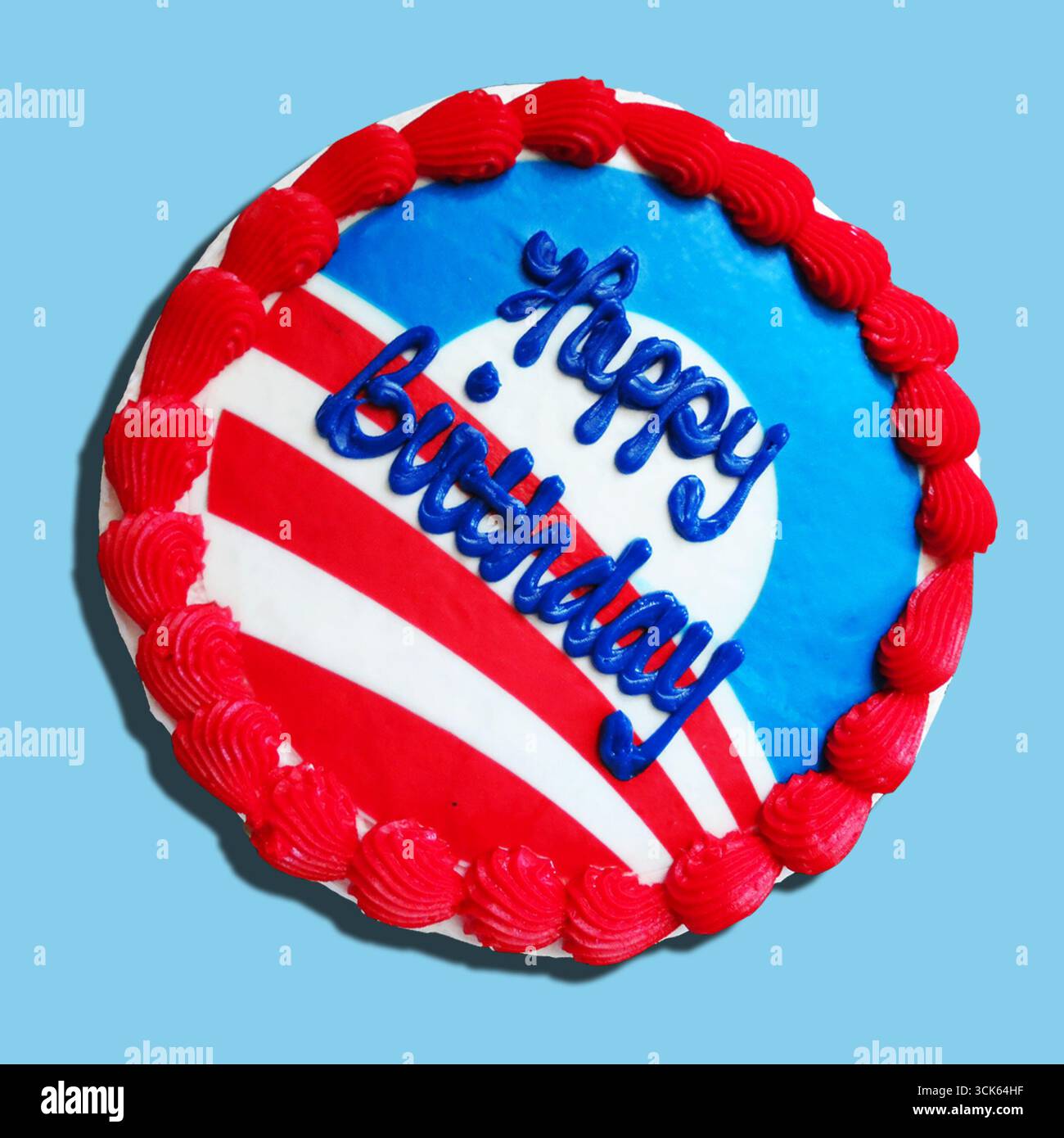 Gâteau d'anniversaire coloré décoré de glaçage rouge, blanc et bleu, avec les mots « joyeux anniversaire » en bleu. Banque D'Images