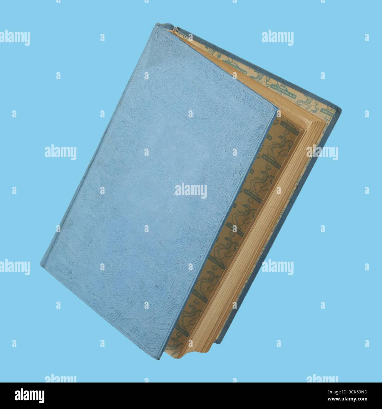 Un livre classique, recouvert de bleu avec des bords décoratifs, symbolisant la connaissance et la littérature. Banque D'Images
