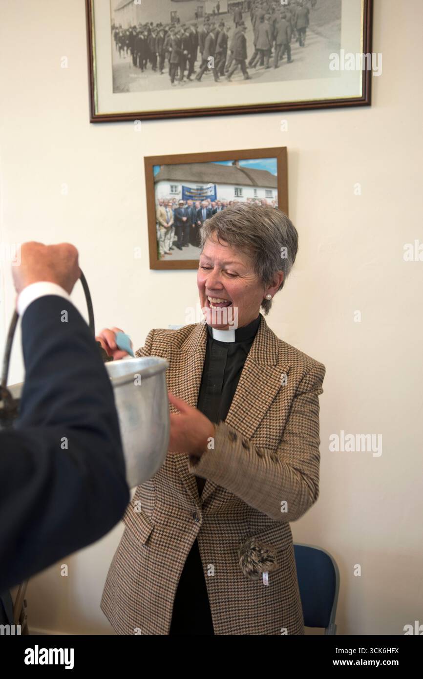 Tirage du billet de tombola effectué par l'invité d'honneur, le Revd. Susan Oldham de l'église St James dans le village d'Iddesleigh. Les billets sont tirés d'un seau à l'Iddesleigh Mens Friendly Society déjeuner annuel Feast Day dans la salle du village de Northcote. Elle porte une veste en tweed et est l'invitée d'honneur. Iddesleigh, Devon, Angleterre 2 mai 2022 Royaume-Uni 2020s HOMER SYKES. Banque D'Images