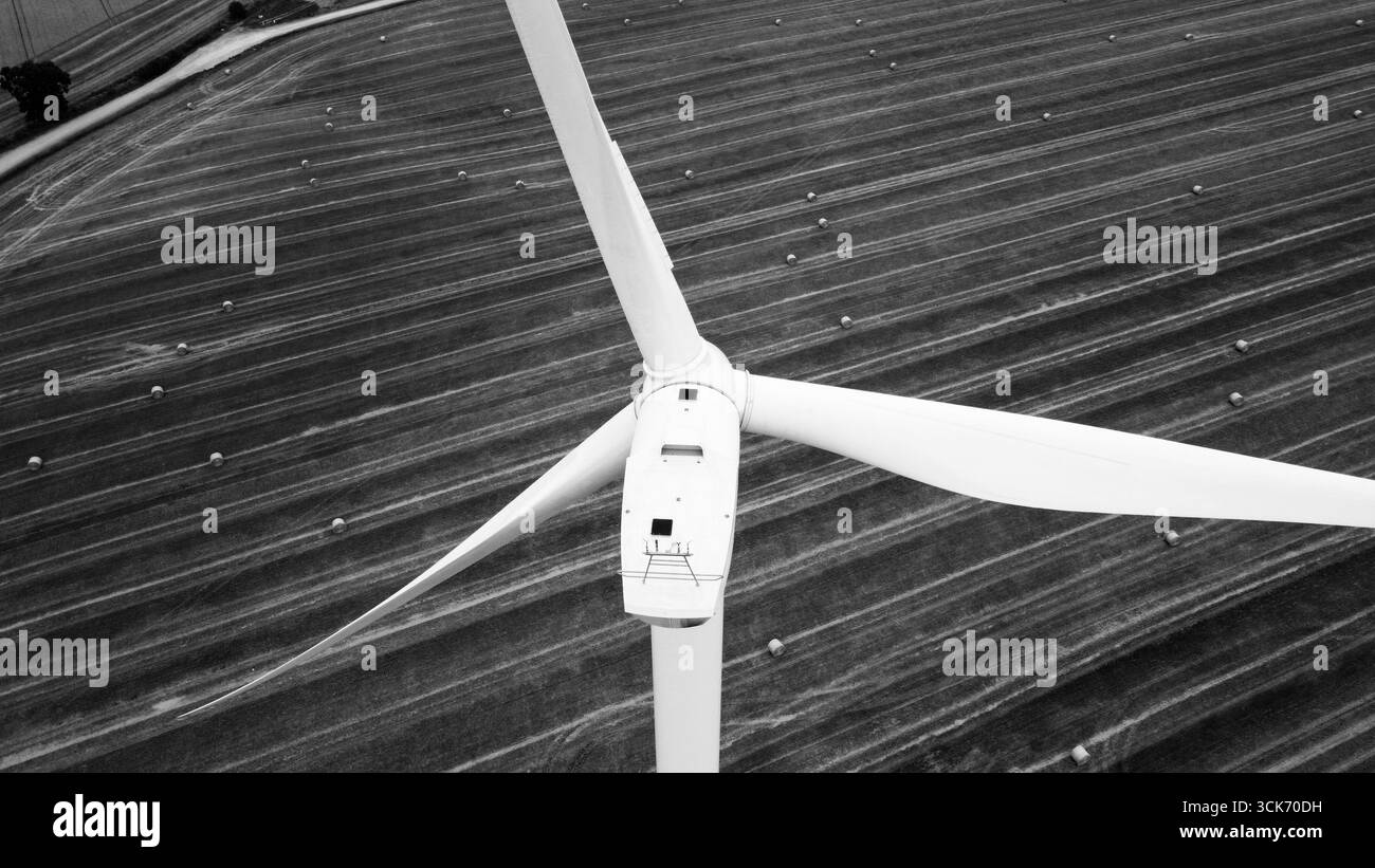 Vue aérienne en noir et blanc de l'éolienne au-dessus des terres agricoles Banque D'Images