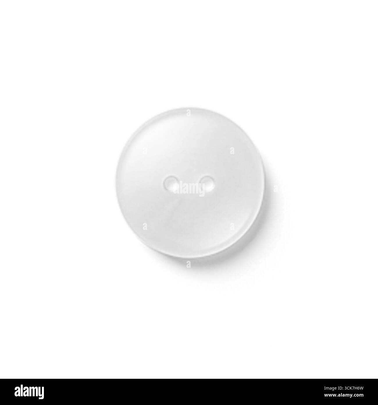 Un bouton en plastique transparent avec deux trous, couramment utilisé dans les projets de vêtements et de couture. Banque D'Images