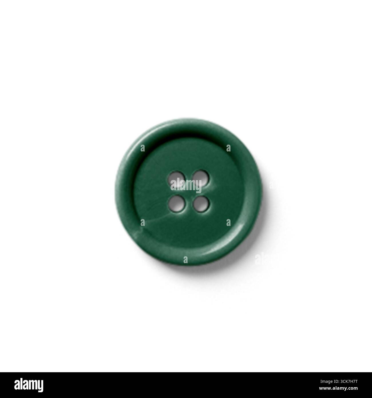 Un bouton vert avec quatre trous, couramment utilisé pour la couture et l'artisanat. Banque D'Images