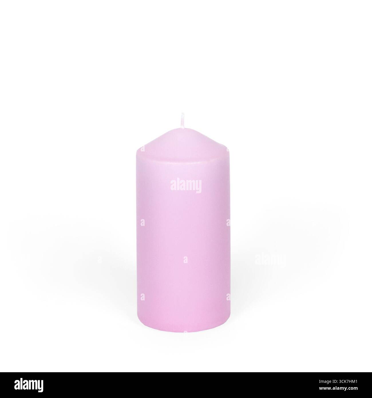 Une bougie rose simple, parfaite pour la décoration ou pour créer une atmosphère apaisante. Banque D'Images