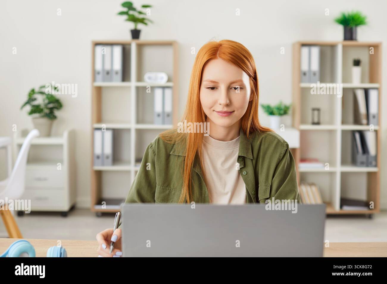 Femme travaillant ou étudiant en ligne à la maison avec Un ordinateur portable sur la table Banque D'Images