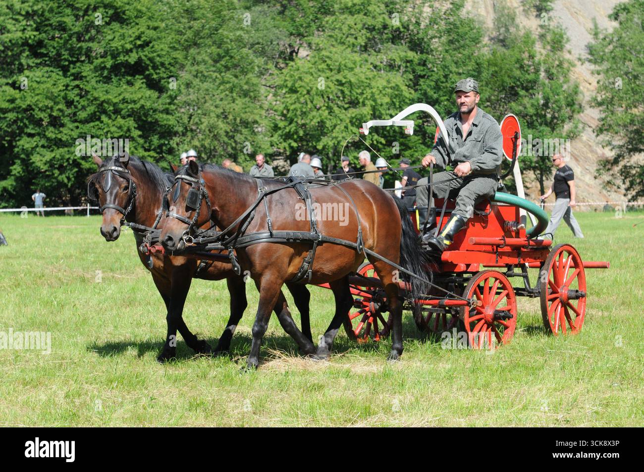 Pompier chevauchant une pompe à incendie vintage tirée par un cheval pendant la compétition à Rudawka Rymanowska, Podkarpackie, Pologne Banque D'Images
