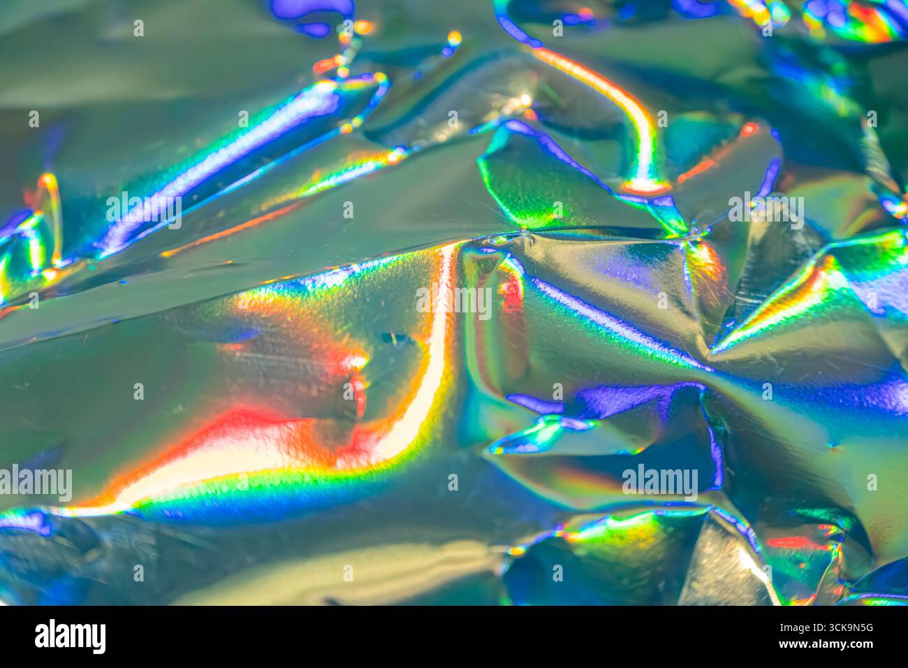 L'image représente un gros plan d'un matériau métallique irisé avec divers reflets de couleur, adapté à la mode, aux bijoux ou à la décoration de son bien éclairé Banque D'Images