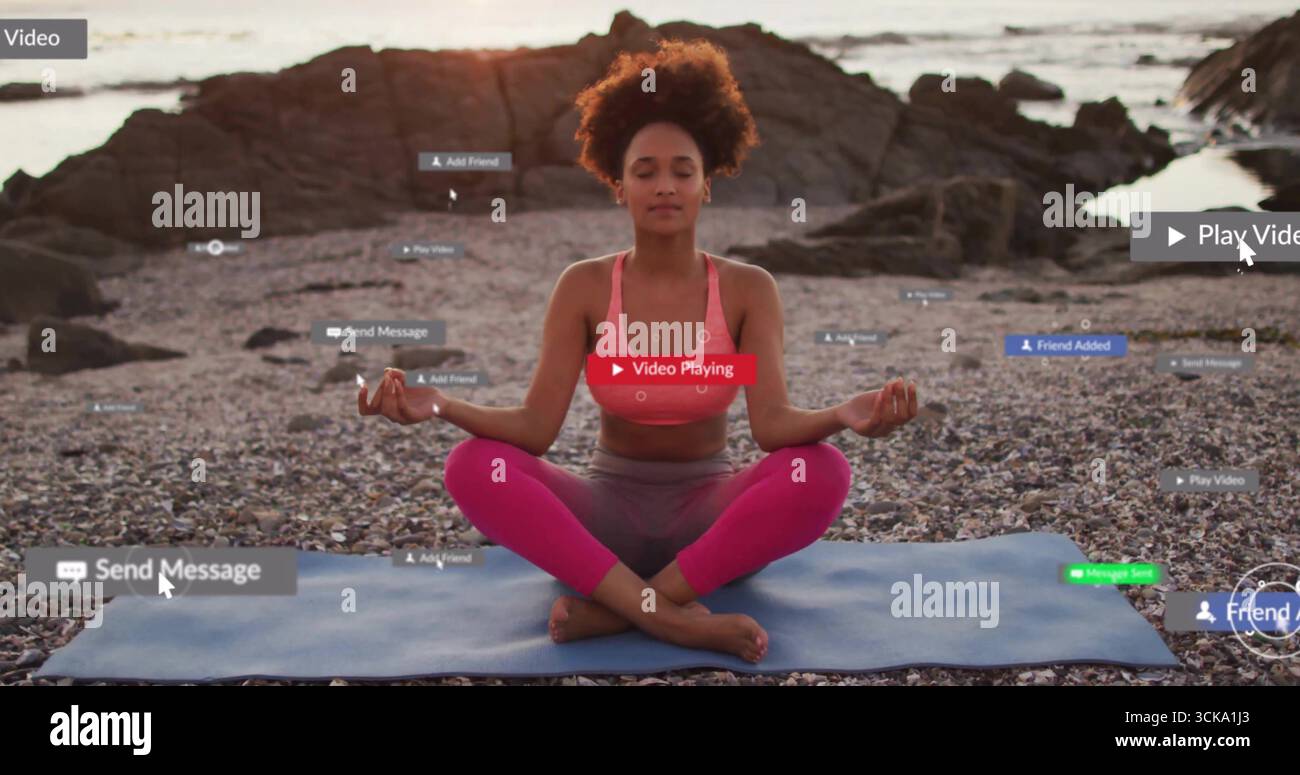 Femme méditante portant un soutien-gorge de sport rose et des leggings assis sur la plage de galets, avec un tapis de yoga bleu Banque D'Images