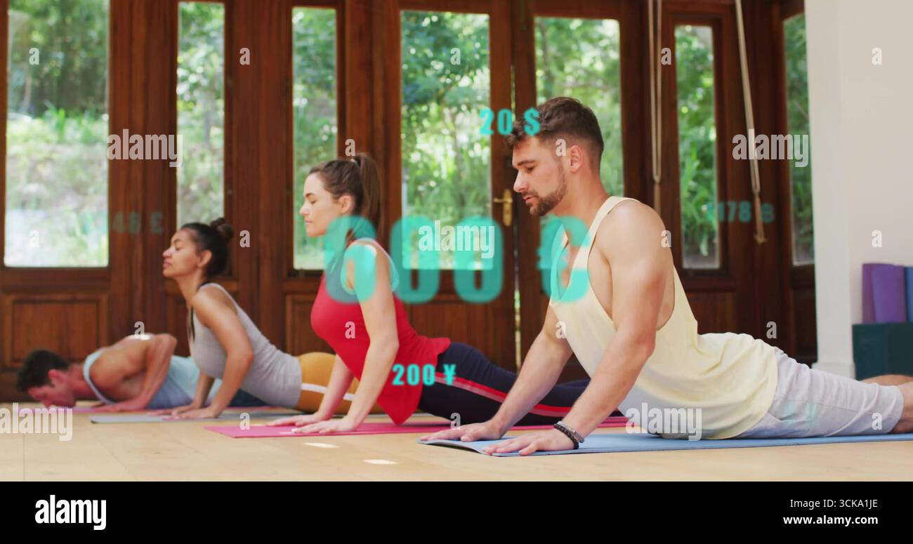 Quatre adultes réalisant une pose de chien orientée vers le haut dans un studio de yoga, des tapis colorés et des blocs de mousse Banque D'Images
