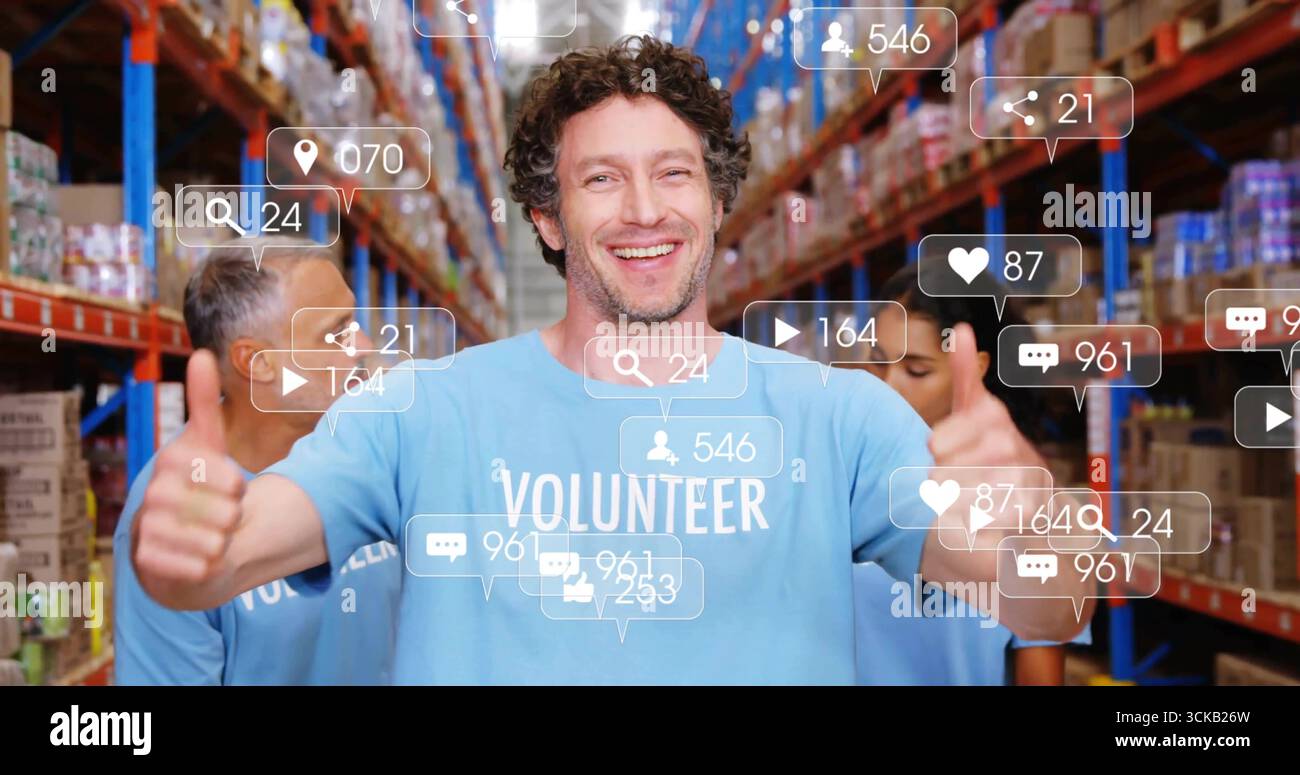 Des bénévoles portant des chemises bleu clair levant les pouces entre les étagères de l'entrepôt, avec des icônes médiatiques Banque D'Images