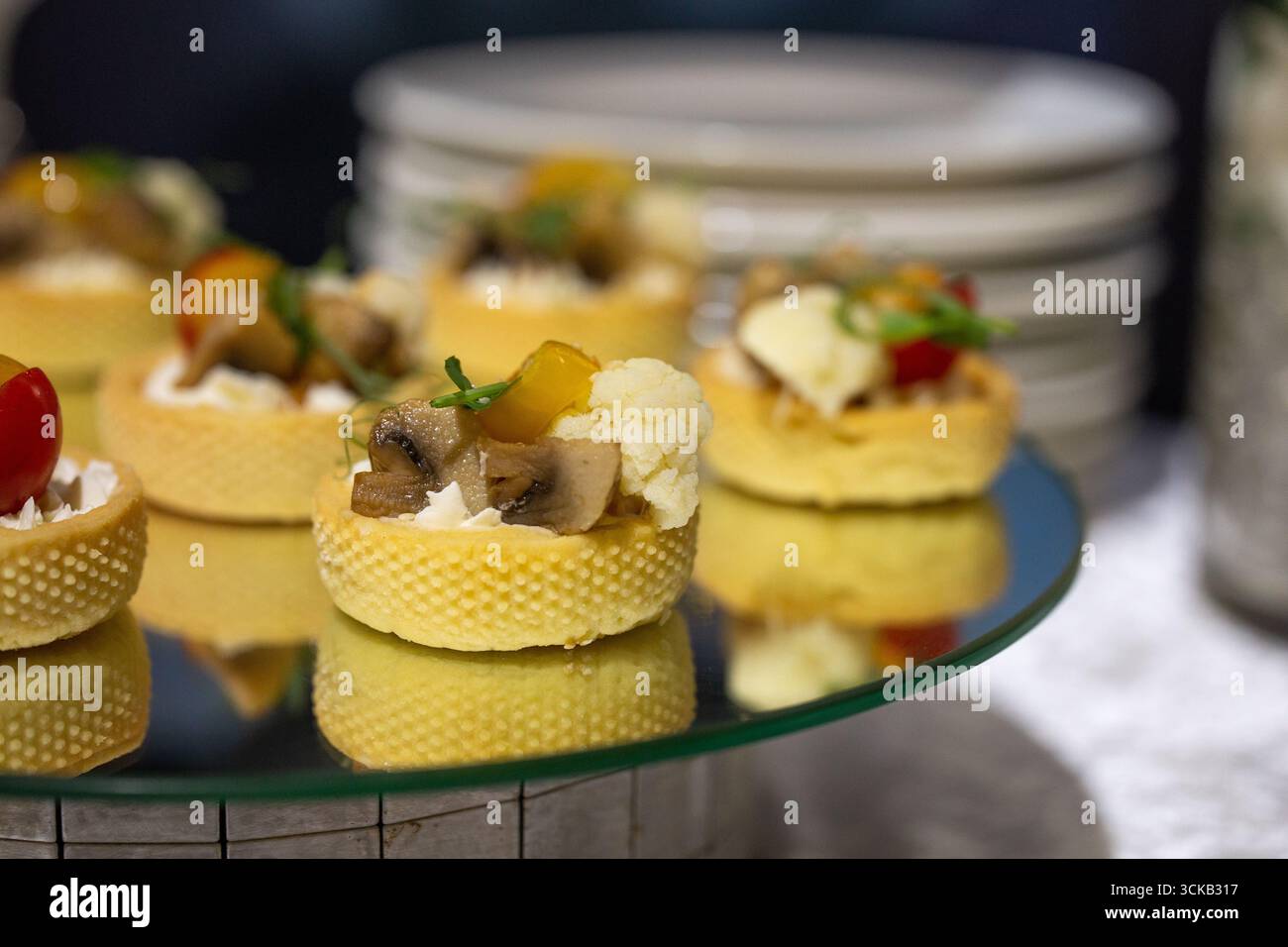 Délicats mini canapés savoureux dans des tasses à pâtisserie croustillantes remplies de champignons, de chou-fleur, de fromage à la crème et d'herbes - des hors-d'œuvre élégants pour les événements, le mariage Banque D'Images