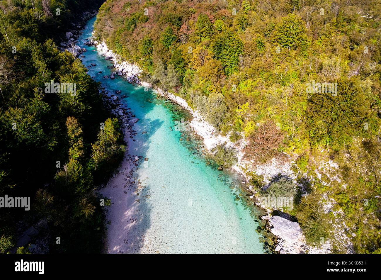 Rivière Soča d'un turquoise cristallin traversant les Alpes juliennes en Slovénie, entourée de montagnes dramatiques et d'un paysage alpin immaculé. Banque D'Images