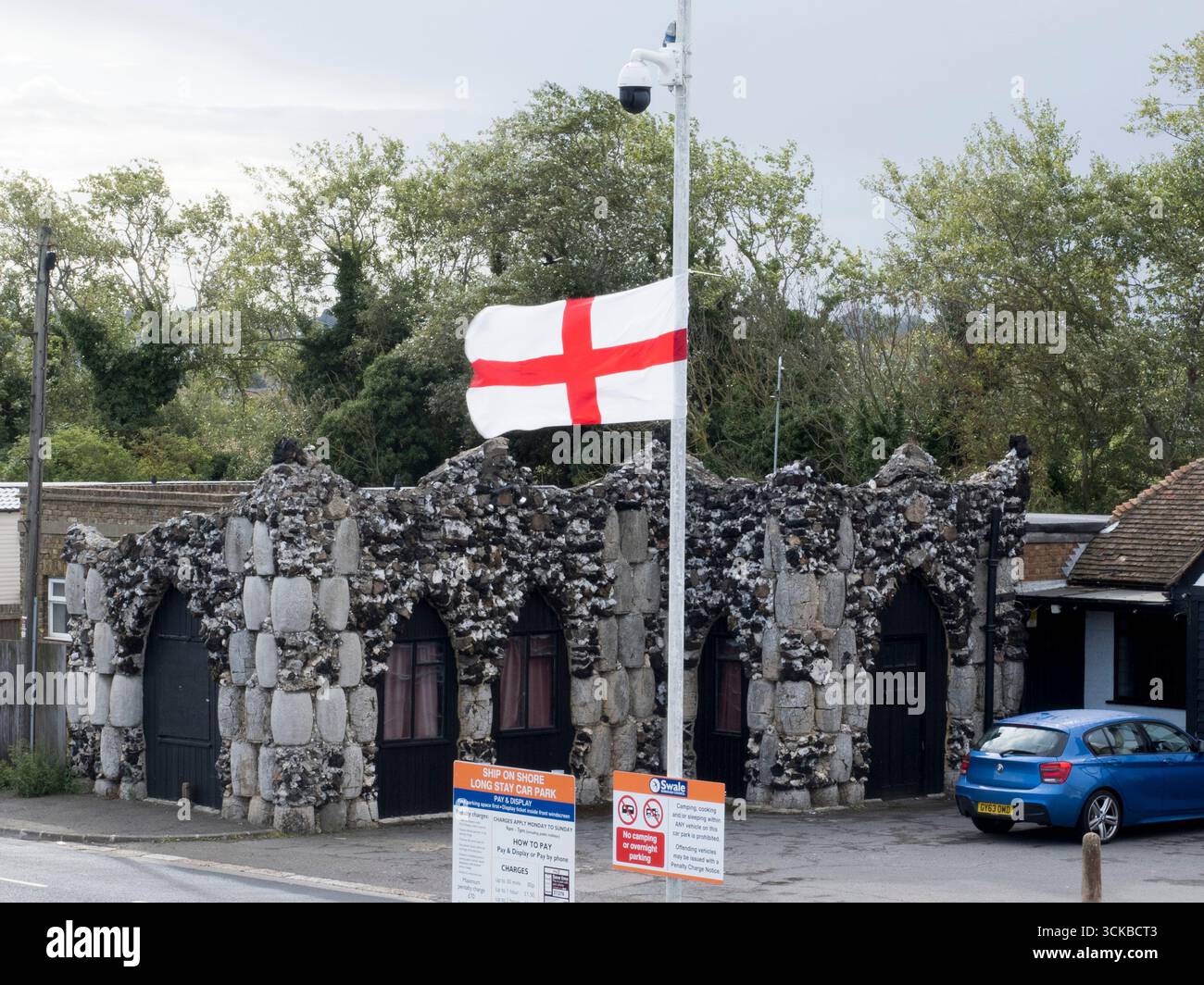 Sheerness, Kent, Royaume-Uni. 11 septembre 2025. Une ligne de drapeaux de St George Cross flottent contre-éclairés par le soleil du matin le long de la route côtière à Sheerness, Kent. L'opération de campagne en ligne Raise the Colours a contribué à augmenter les ventes de drapeaux d'environ 20 pour cent. Crédit : James Bell/Alamy Live News Banque D'Images