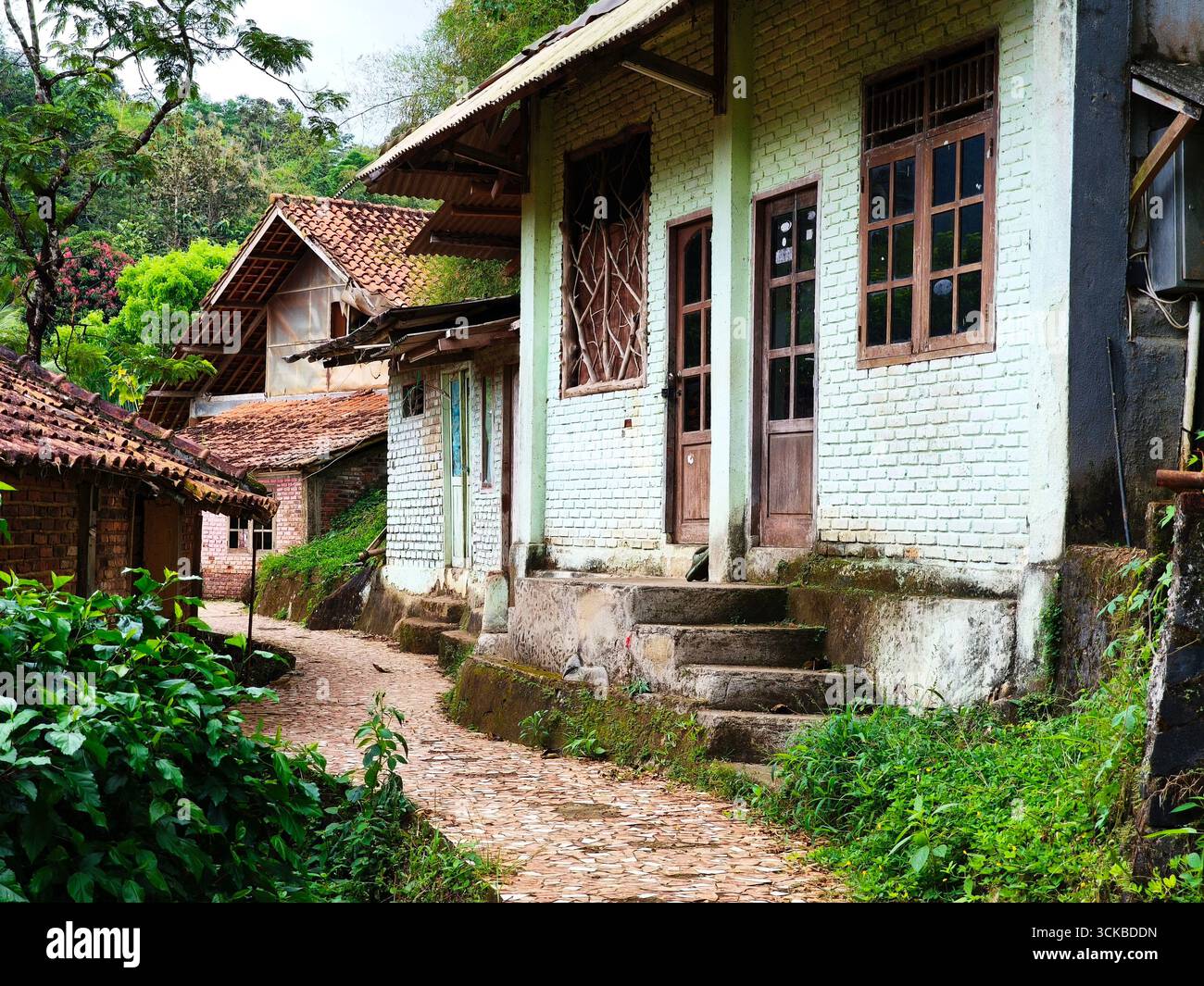 Une scène de village paisible avec des maisons traditionnelles avec des toits de tuiles et des murs de briques. Le chemin est fait de pierre Banque D'Images
