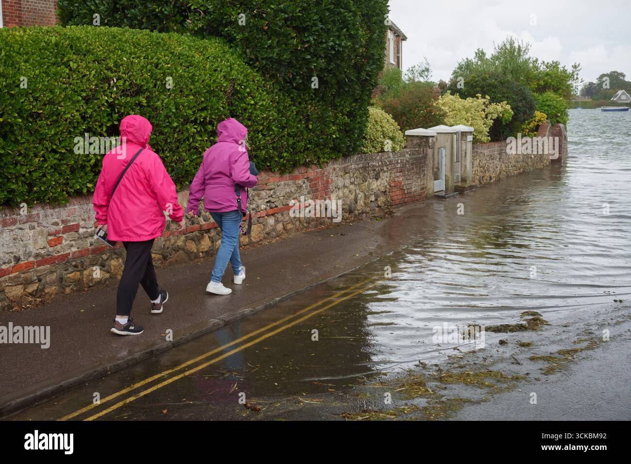 Les habitants et les visiteurs négocient les eaux de crue pendant la plus haute marée de l'année qui a inondé les voies à Bosham, le 10 septembre 2025, à Bosham, en Angleterre. La marée haute de Bosham à 14,02 le 10 septembre 2025, était un maximum de 5,04 mètres. Banque D'Images