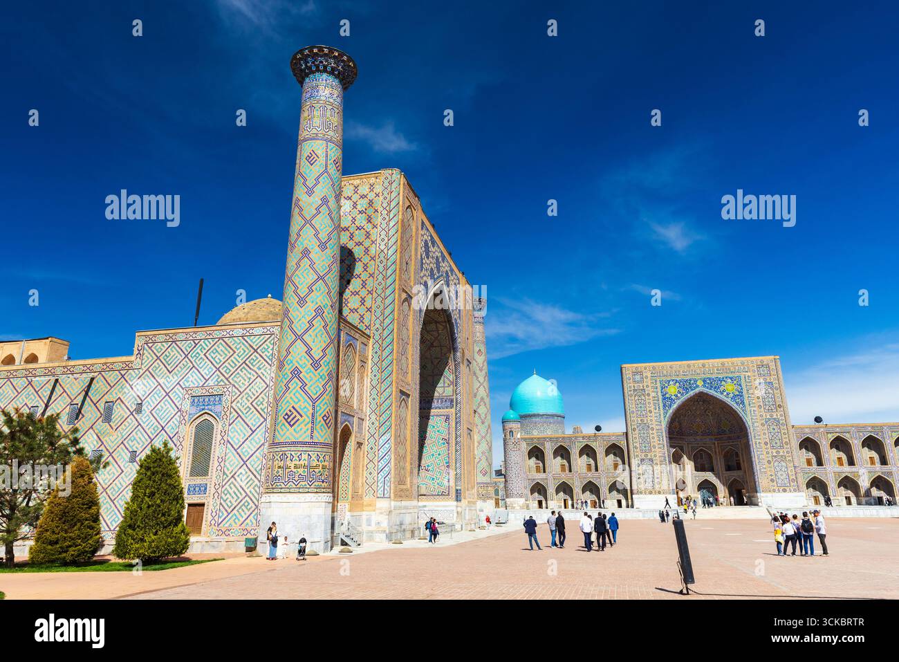Samarcande, Ouzbékistan - 25 mars 2024 : les touristes sont sur la place du Registan par une journée ensoleillée. Ulugh Beg Madrasah, Tilya-Kori Madrasah sont sur le backgro Banque D'Images