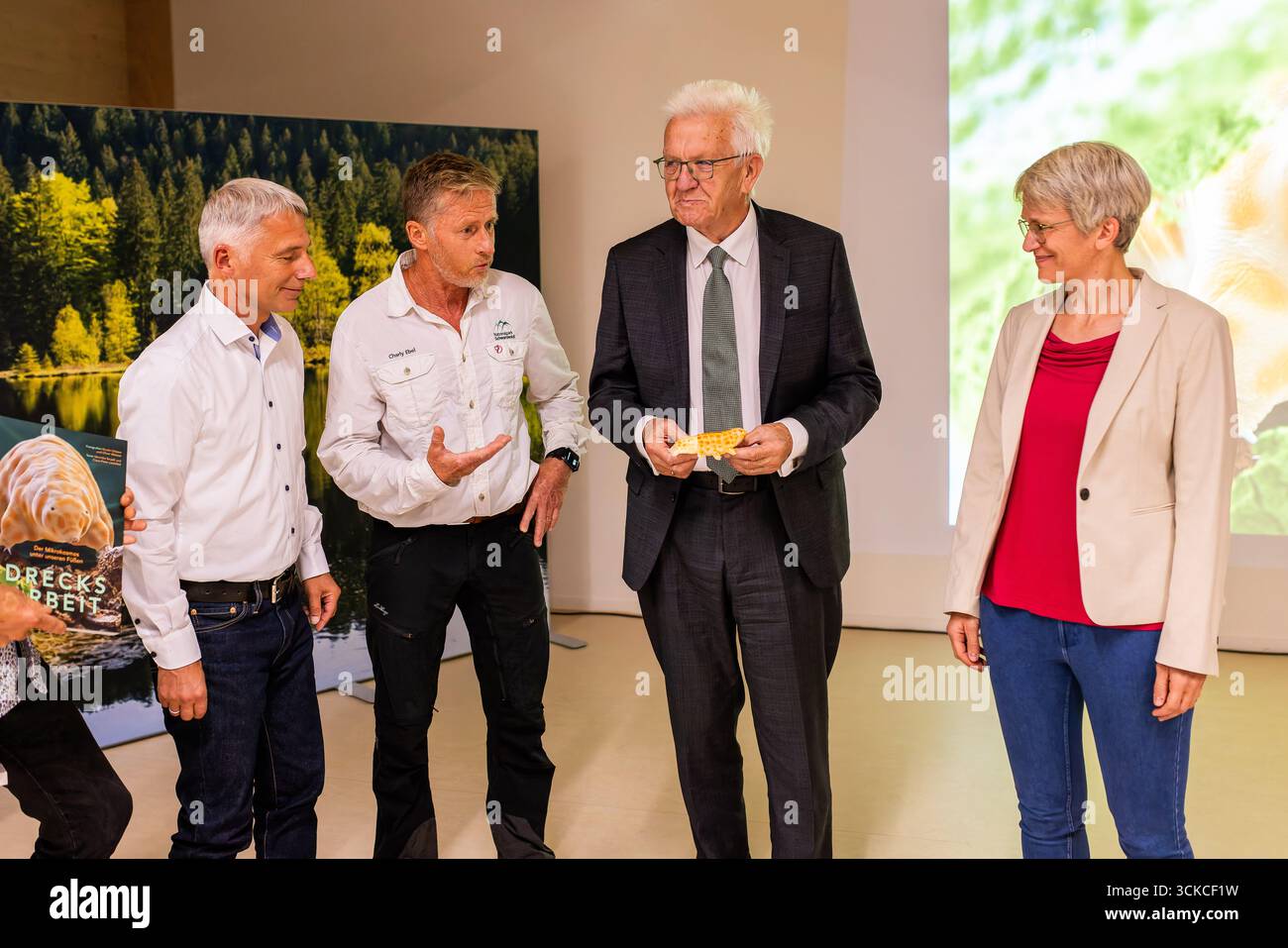 11 septembre 2025, Bade-Württemberg, Baiersbronn : Ralph Schill, Université de Stuttgart, Charly Ebel, parc national de la Forêt-Noire, Winfried Kretschmann (Bündnis 90/Die Grünen), ministre-président du Bade-Württemberg, et Britta Böhr, directrice adjointe du parc national de la Forêt-Noire, présentent un modèle du tardigrade récemment découvert au Centre du parc national de la Forêt-Noire. Un tardigrade nouvellement découvert a été nommé 'Ramazzottius kretschmanni', selon l'administration du parc national de la Forêt Noire. Les tardigrades sont de minuscules créatures qui vivent principalement dans des zones humides et sont chara Banque D'Images